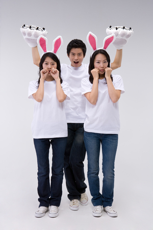 Two Asian women and a man posing in a studio with animal propsの写真素材