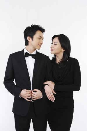 Dressed up Asian couple posing in a studioの写真素材