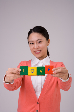 Kindergarten teacher posing in a studio with letter blocksの写真素材