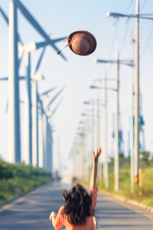 a woman throwing a straw hat in the airの写真素材