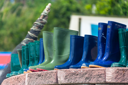 Rubber boots being dried as standing in rowsの写真素材