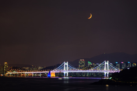 Night view of lit city under the new moonの写真素材