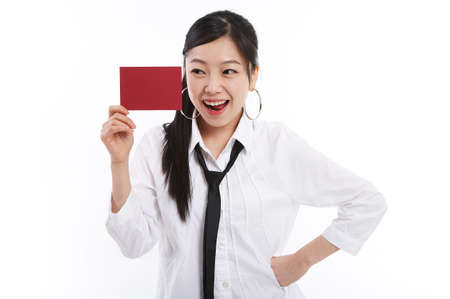 Young female fashionable Asian posing in a studio with red message boardの写真素材