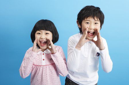 Young Asian girl and boy posing in a studioの写真素材