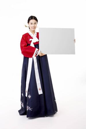 Korean woman wearing traditional costume posing in a studio with message boardの写真素材