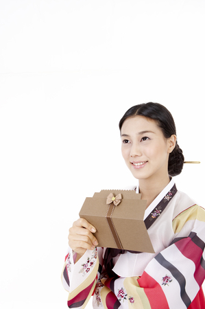 Korean woman wearing traditional costume posing in a studio with gift money envelopeの写真素材