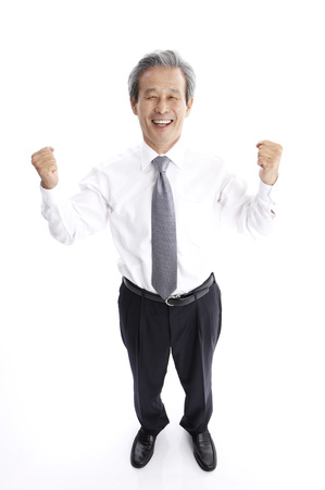Male Asian elderly in suit posing in a studio with hand gestureの写真素材