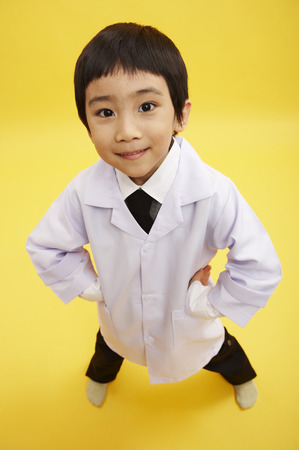 Young Asian boy wearing doctor robe posing in a studioの写真素材