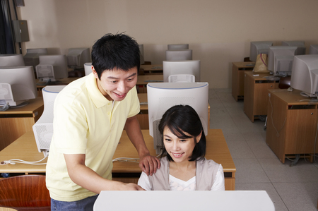 Asian college couple posing in a computer labの写真素材