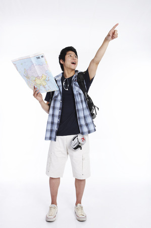 Asian man posing in a white studio with a mapの写真素材