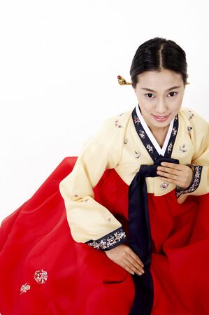 Korean woman wearing traditional costume posing in a studio as sitting downの写真素材