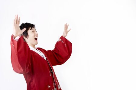 Korean man wearing traditional costume posing in a studio with hand gestureの写真素材