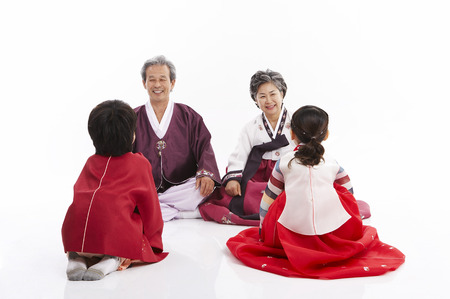 Grandparents and grandchildren in korean costume isolated in white backgroundの写真素材