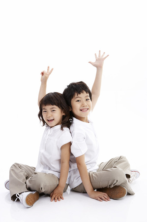 Young Asian boy and girl posing together in a studioの写真素材