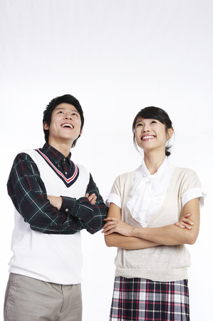 Asian couple posing in a white studio with toothy smilesの写真素材