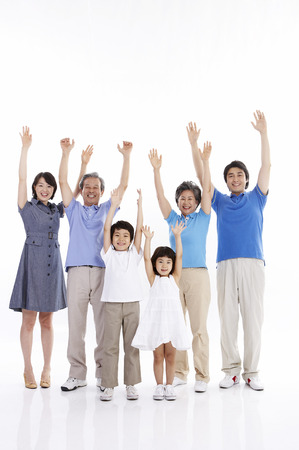 Three generations of Asian family posing in a studio with hand gesturesの写真素材