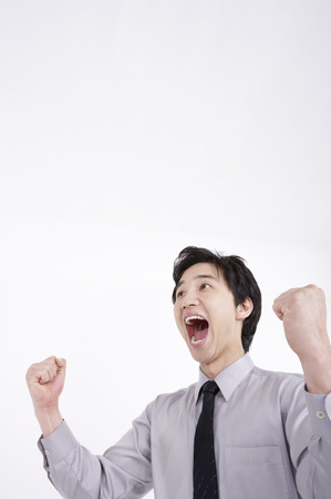Close up shot of Asian business man in suit posing in a studio with gestureの写真素材