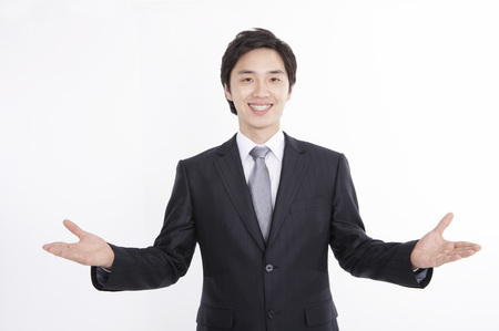 Asian business man in suit posing in a studio with gestureの写真素材