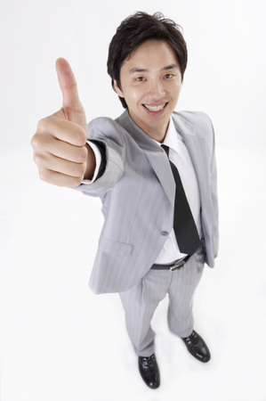 Asian business man in suit posing in a studio with gestureの写真素材