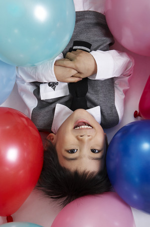 Young Asian children posing in a party room with balloonsの写真素材