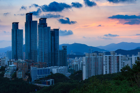 Aerial scenery of building forest with mountains in the back at sunsetのeditorial素材