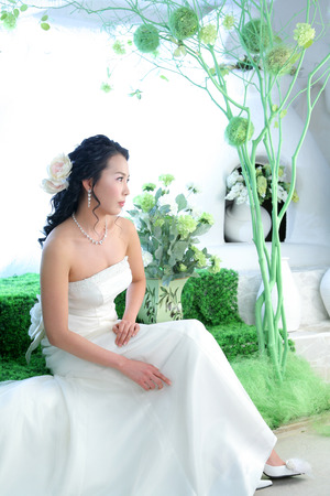 Asian bride in wedding dresses posing in a studio as sitting downの写真素材