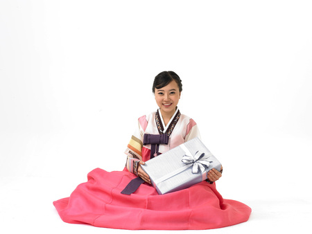 Korean woman wearing traditional costumes posing in a studio with a giftboxの写真素材