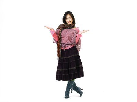 Young Asian female fashion model posing in a studio wearing fall skirt outfit with leather bootsの写真素材