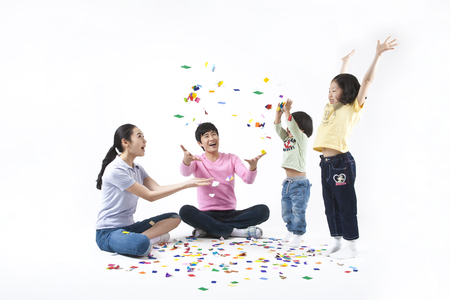 Parents and young kids spending family time together as playing with origamiの写真素材