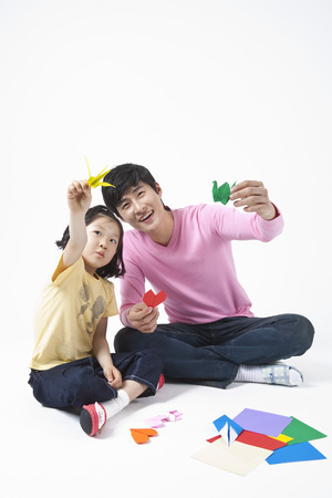 Father and daughter spending family time together with origamiの写真素材