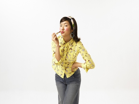 Asian woman fashion model posing in a studio as wearing cute pattern shirt and hair band