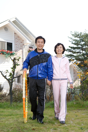 Mid-aged married Asian couple working out as wearing training suitsの写真素材