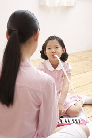 Mother and daughter spending family time with musical instrumentsの写真素材