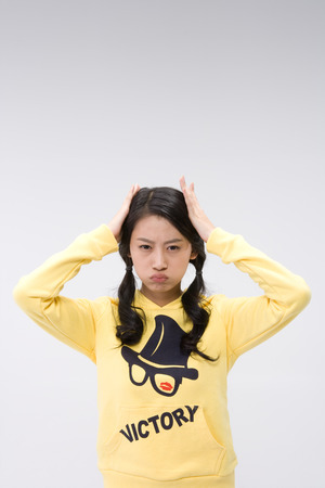 Young Asian girl looking stressed - isolated on whiteの写真素材