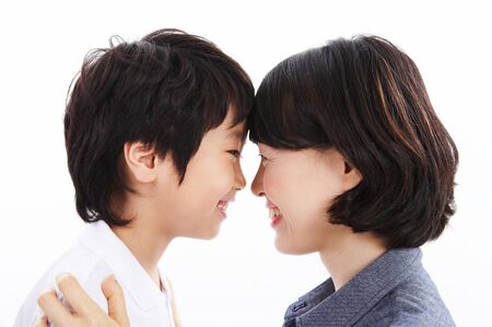 Asian mom and her son looking at each other closely - isolated on whiteの写真素材