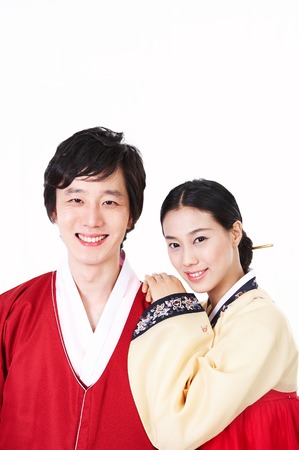 Young Asian couple in Hanbok, Korean traditional attire posing in the studio - isolated on whiteの写真素材