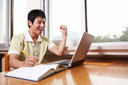 Asian male university student studying in the libraryの写真素材