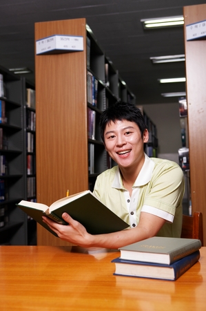 Asian male university student studying in the libraryの写真素材