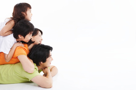 Asian family stacking on top of each other - isolated on whiteの写真素材