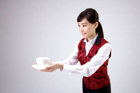 Young Asian female server serving food - isolated on whiteの写真素材
