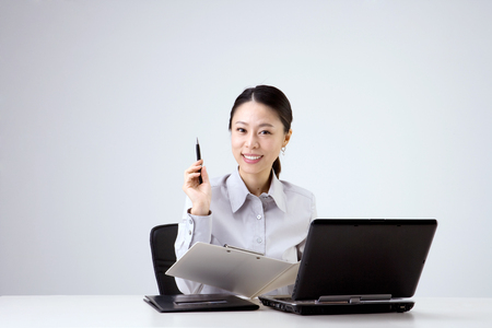 Asian business woman working in the office - isolated on whiteの写真素材