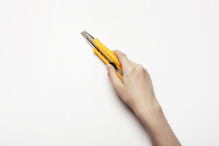 Hand with a cutter knife - isolated on whiteの写真素材