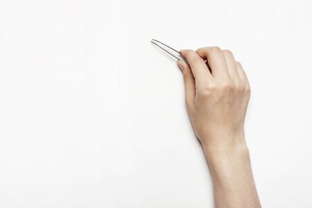 Hand with a tweezer - isolated on whiteの写真素材