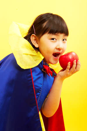 Close up of Asian girl in the Snow White uniform eating appleの写真素材
