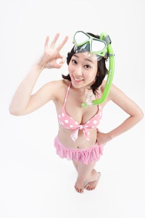 Asian bikini swimsuit woman with swimming goggles isolated on whiteの写真素材
