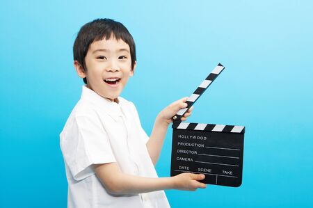 Close of Asian boy holding a clapboardの写真素材