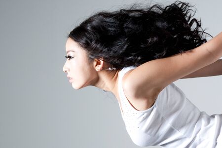 Asian stylish woman posing striking pose isolated on whiteの写真素材