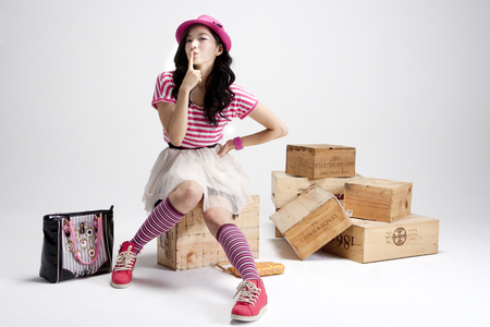 Asian stylish woman sitting on box isolated on whiteの写真素材