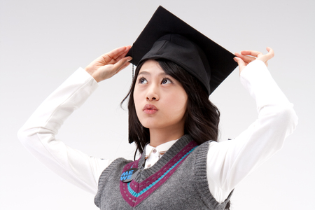 Close up Asian young woman with graduation cap isolated on whiteの写真素材