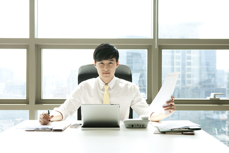 Asian business man with paper in officeの写真素材